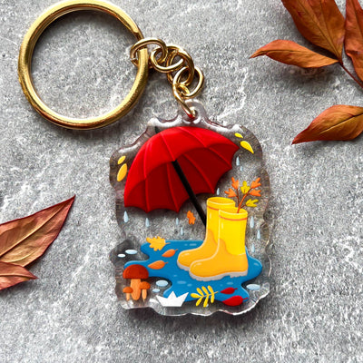 Autumn umbrella and rain boots transparent acrylic keychain. Double-sided, backside is the same design, but reversed.